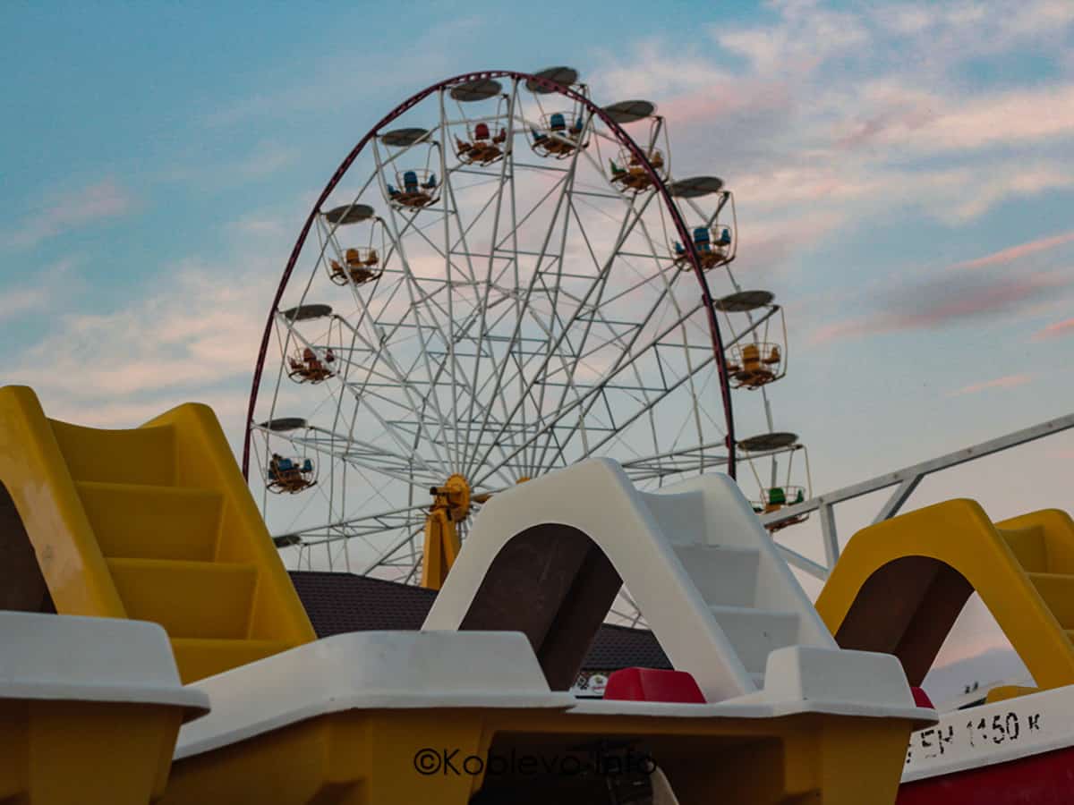 Катамараны на пляже возле колеса обозрения в Коблево